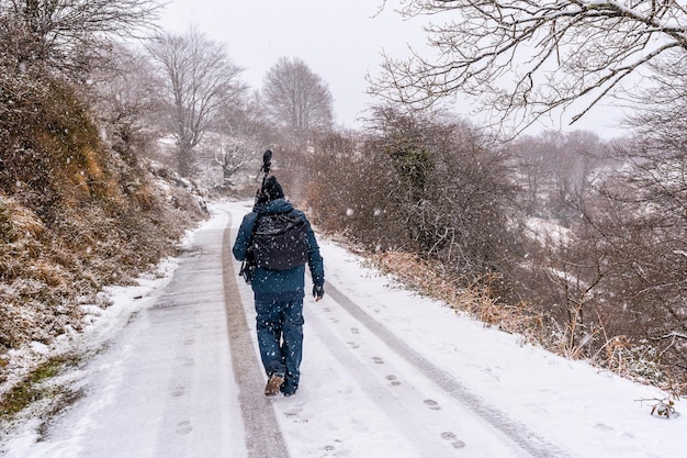 Un jeune photographe sur la route enneigée du Mont Aizkorri à Gipuzkoa