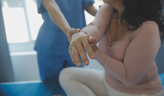 Jeune physiothérapeute asiatique travaillant avec une femme âgée sur la marche avec un déambulateur