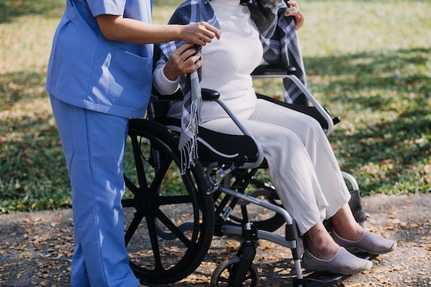 Jeune physiothérapeute asiatique travaillant avec une femme âgée sur la marche avec un déambulateur