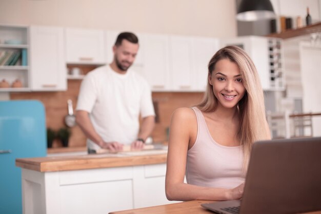 Jeune pigiste travaillant sur un ordinateur portable dans la cuisine