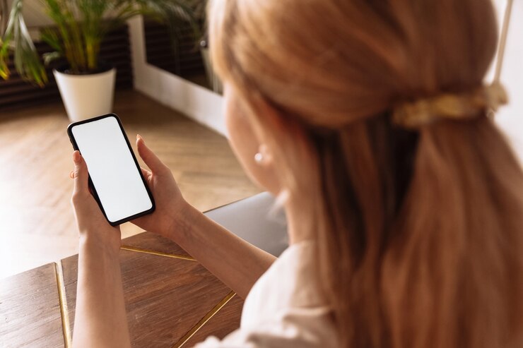 Un jeune pigiste travaille à domicile en utilisant un téléphone