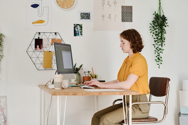 Jeune pigiste ou webdesigner sérieuse se concentrant sur le travail