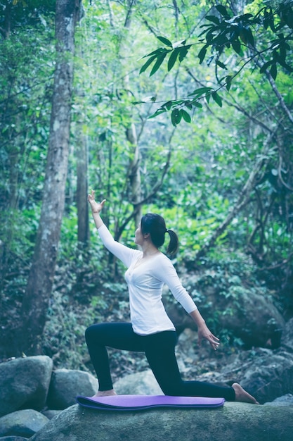 Jeune pratiquant de yoga faisant du yoga sur la nature.