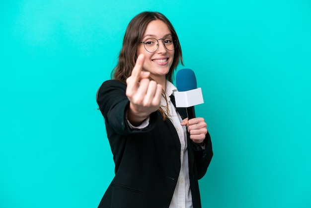 Jeune présentatrice de télévision femme isolée sur fond bleu faisant un geste à venir