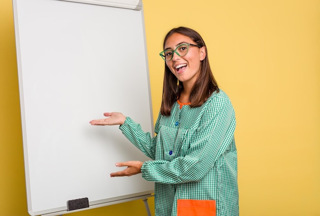 Jeune professeur d'éducation des enfants caucasien expliquant sur le tableau noir isolé