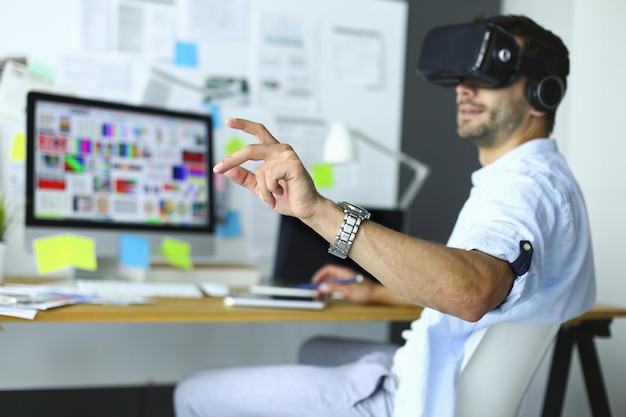 Photo jeune programmeur de logiciel masculin testant une nouvelle application avec des lunettes de réalité virtuelle 3d au bureau