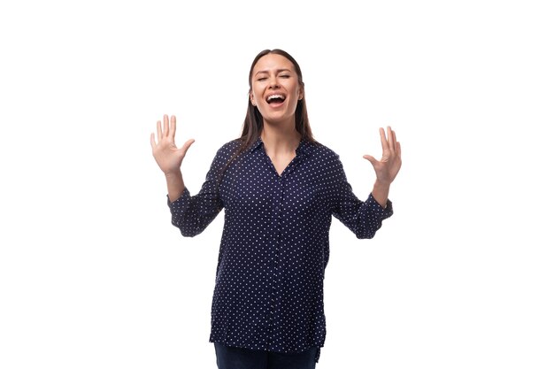 Une jeune publicitaire brune vêtue d'un blouse bleue avec un motif de pois se réjouit et crie