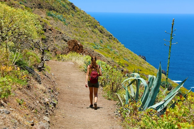 Jeune randonneur femme marchant sur un sentier donnant sur la mer à Tenerife