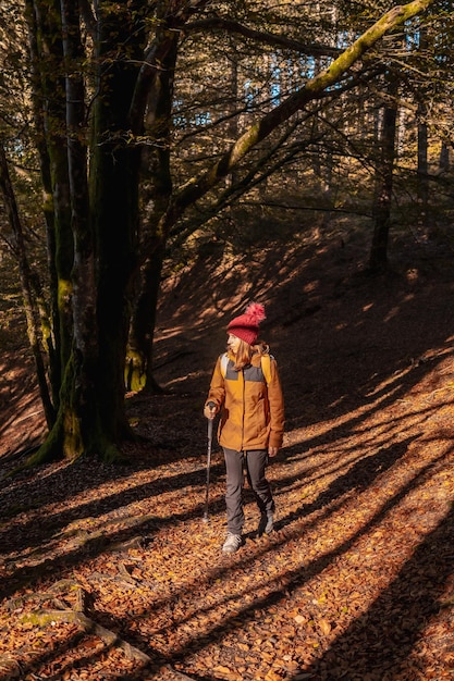 Un jeune randonneur sur un sentier dans le parc naturel d'Artikutza un après-midi d'automne