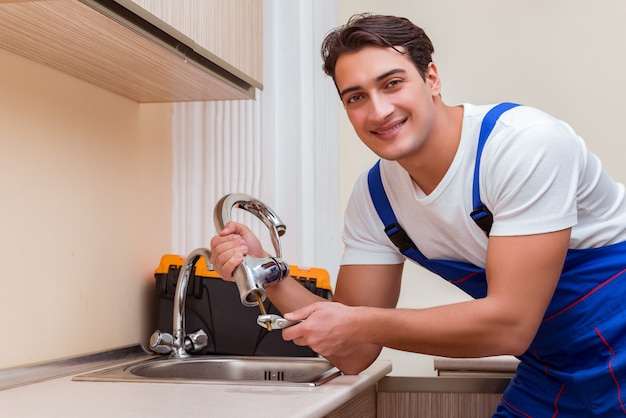 Jeune réparateur travaillant à la cuisine