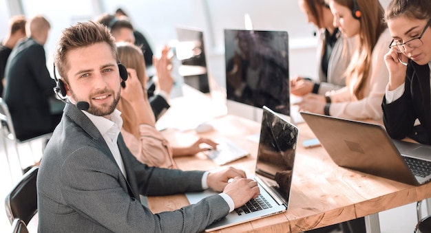 Jeune représentant du service client assis derrière un bureau