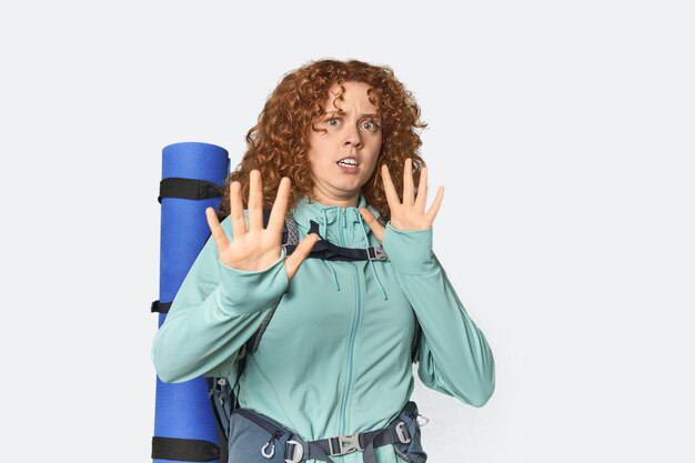 Une jeune rousse blanche prête pour la randonnée est choquée par un danger imminent.