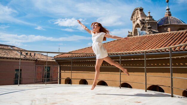 Jeune rousse jolie fille danse en plein air