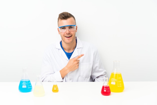 Jeune scientifique avec beaucoup de fiole de laboratoire pointant le doigt vers le côté