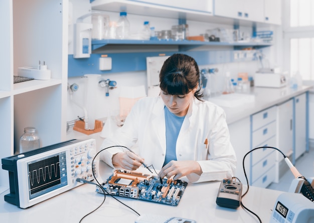 Un jeune scientifique répare un appareil électronique