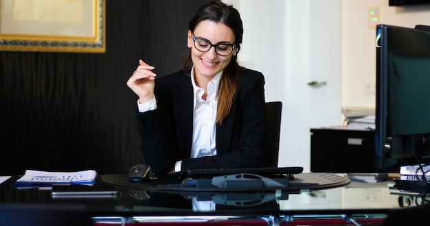 Photo jeune secrétaire réfléchie à l'aide d'une tablette numérique à son bureau