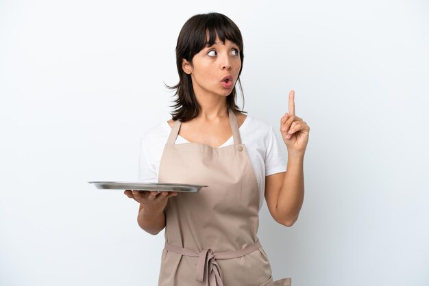 Jeune serveuse avec plateau isolé sur fond blanc pensant une idée pointant le doigt vers le haut