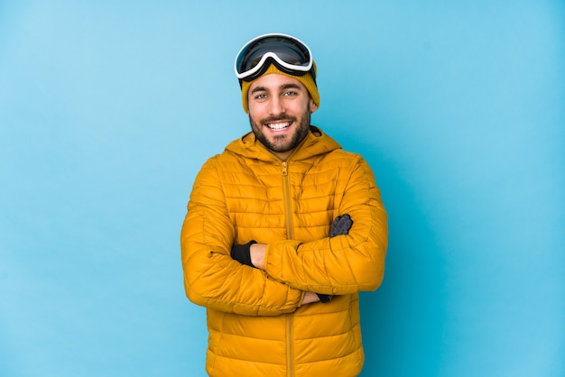 Jeune skieur caucasien isolé en riant et en s'amusant.