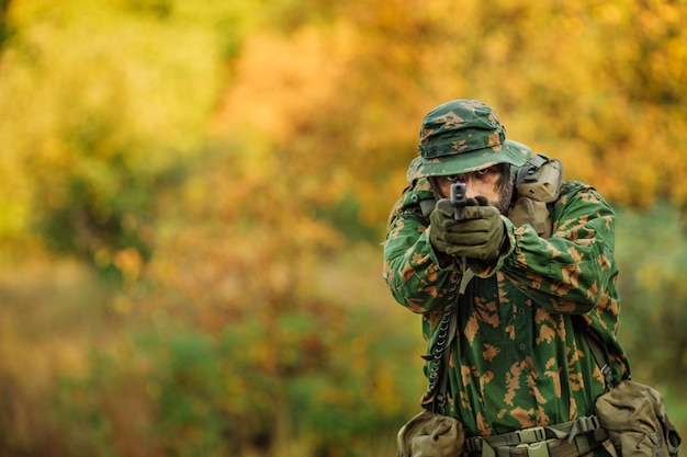 Jeune soldat visant et tirant avec un pistolet