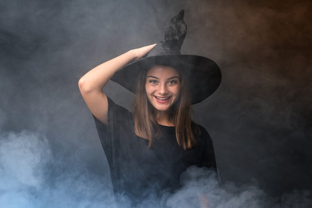 Jeune sorcière tenant des ballons à air noir et orange pour des fêtes d'halloween