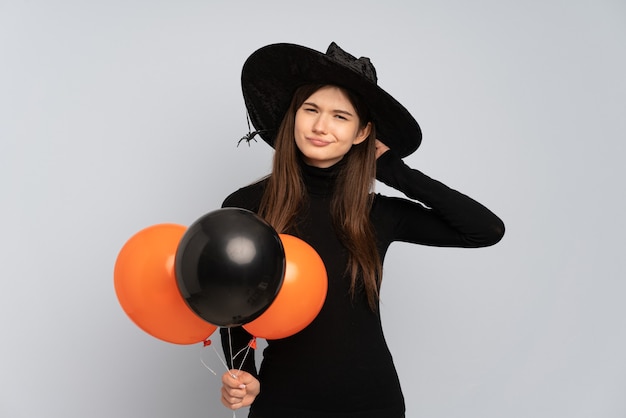 Jeune sorcière tenant des ballons à air noir et orange