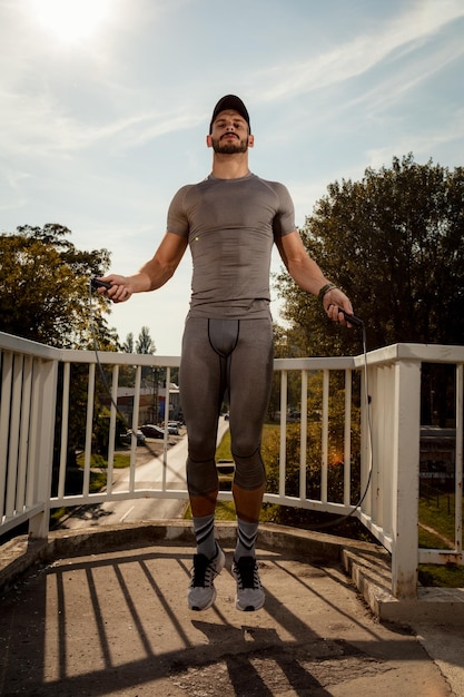 Jeune sportif faisant de l'exercice sur le pont. Regarder la caméra.