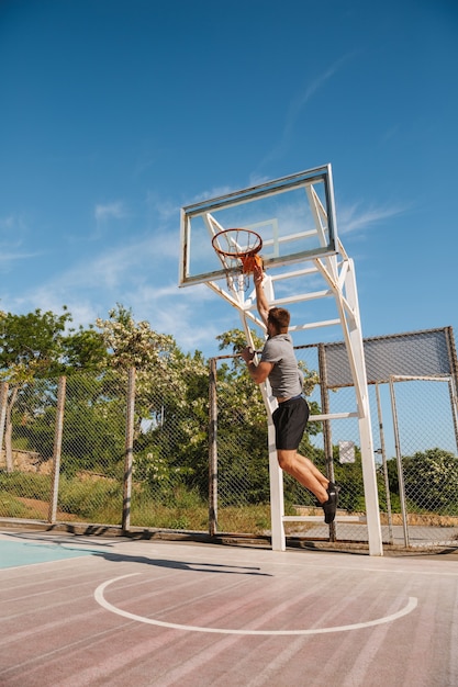 Jeune sportif jouant au basket sur un court