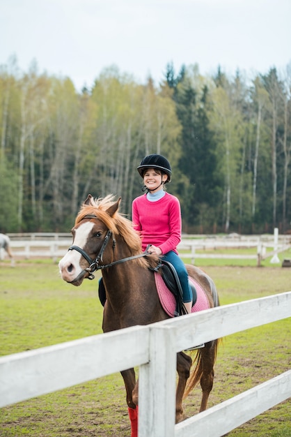 Jeune sportive à cheval dans le spectacle équestre saute la concurrence. Adolescente monter à cheval