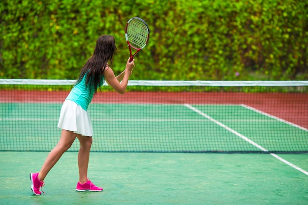 Jeune sportive jouant au tennis en vacances tropicales