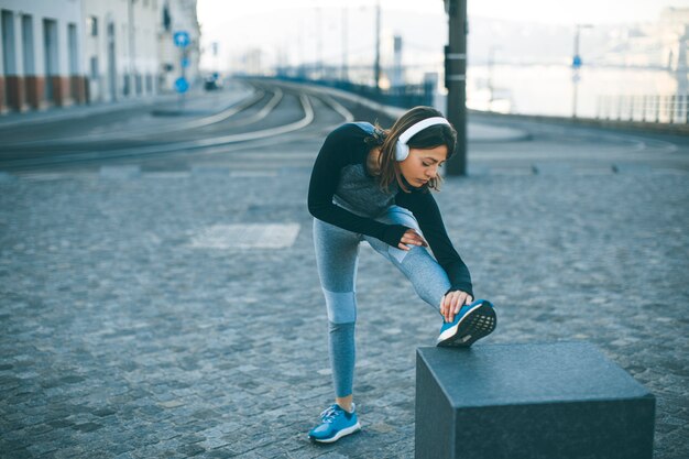 Jeune sportive qui s&#39;étend et se prépare à courir