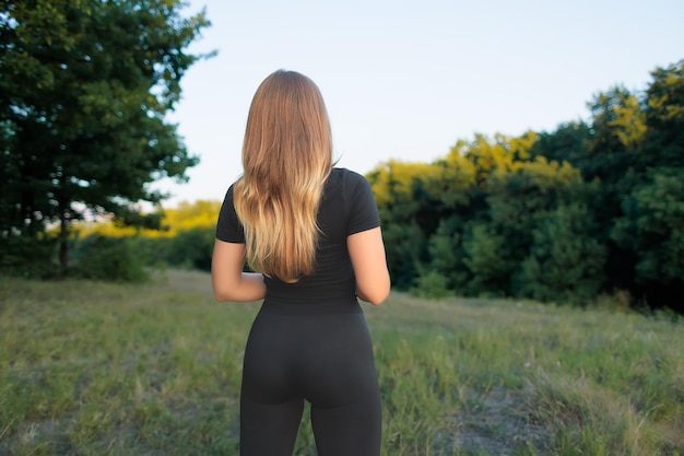 Une jeune sportive se tient dos à elle et regarde au loin