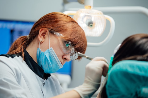 Jeune stomatologue traitant les dents du patient.