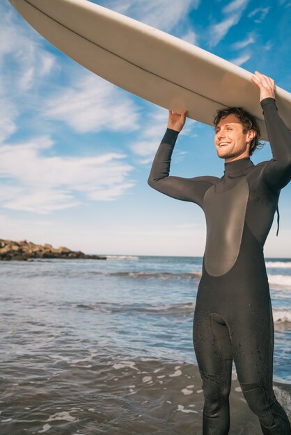 Jeune surfeur brandissant sa planche de surf.