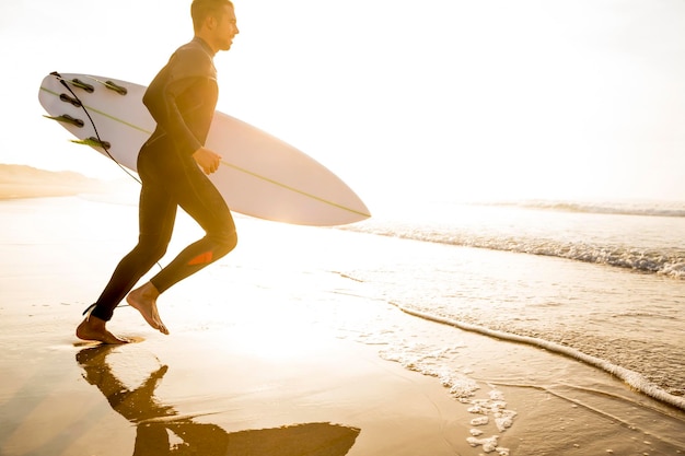 Photo un jeune surfeur prêt à attraper des vagues.