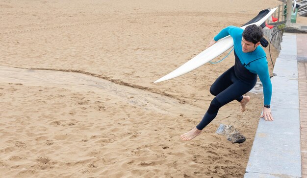 Jeune surfeur se dirigeant vers les vagues copie de l'espace