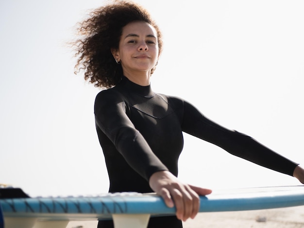 Jeune surfeuse multiraciale avec portrait de cheveux afro