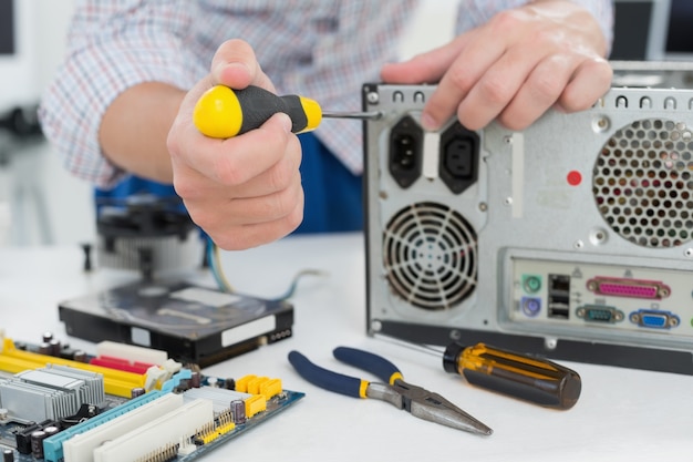 Jeune technicien travaillant sur un ordinateur cassé