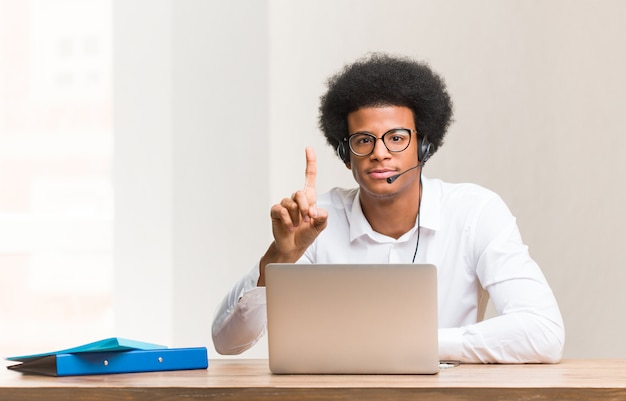 Jeune télévendeur homme noir montrant le numéro un