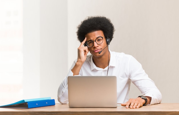 Jeune télévendeur noir pensant à une idée