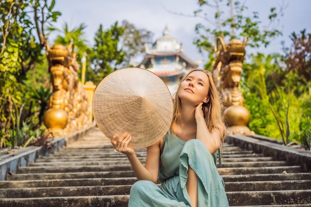 Une jeune touriste dans un chapeau traditionnel vietnamien voyage au Vietnam