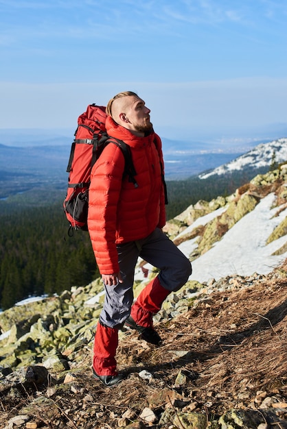 Un jeune touriste grimpe au sommet de la montagne