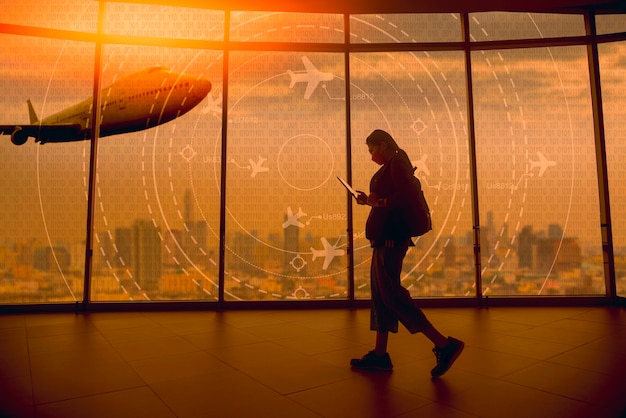 Un jeune touriste passe devant un écran simulé montrant divers vols pour le transport et les passagers