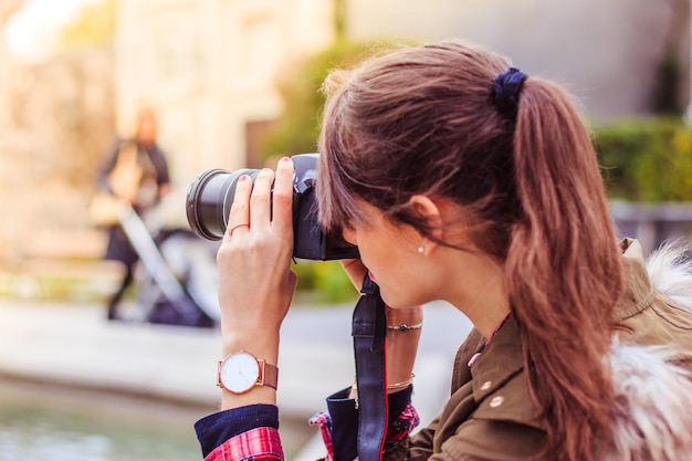 Une jeune touriste prend des photos avec son appareil photo