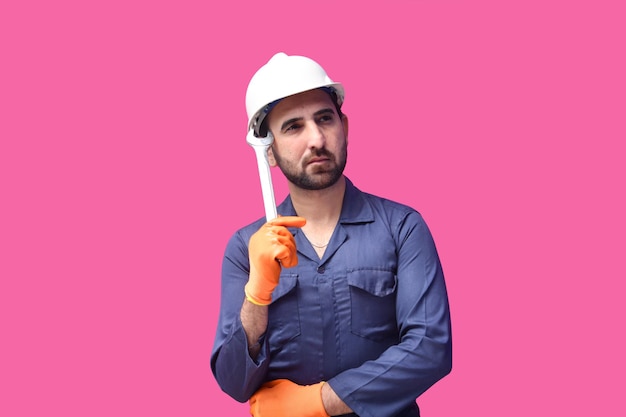 Jeune travailleur de la construction portant une chemise bleue et tenant une clé modèle pakistanais indien