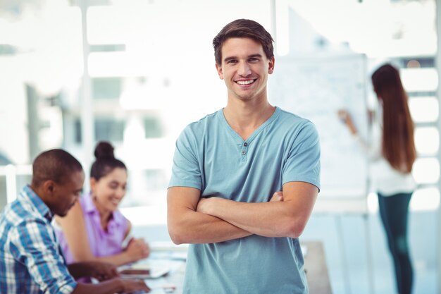 Jeune travailleur créatif, souriant à la caméra