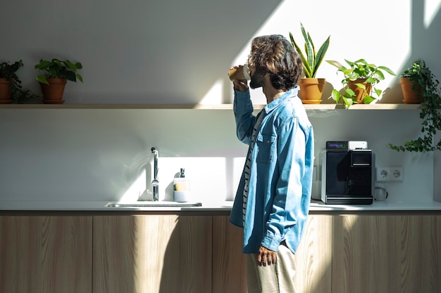 Jeune travailleur masculin hispanique buvant du café dans la cuisine du bureau Pause-café au bureau Espace de copie