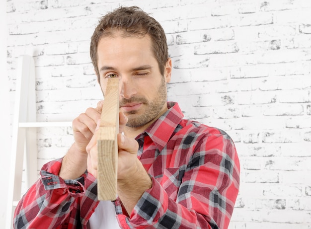 jeune travailleur avec une planche de bois