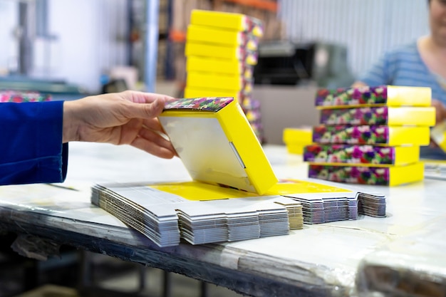 Jeune travailleuse emballant des boîtes pour expédition dans un entrepôt.