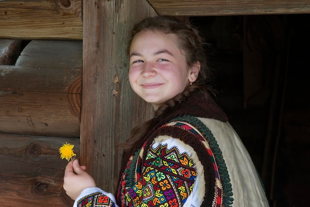 Photo une jeune ukrainienne en tenue nationale avec une fleur de pissenlit à la main.