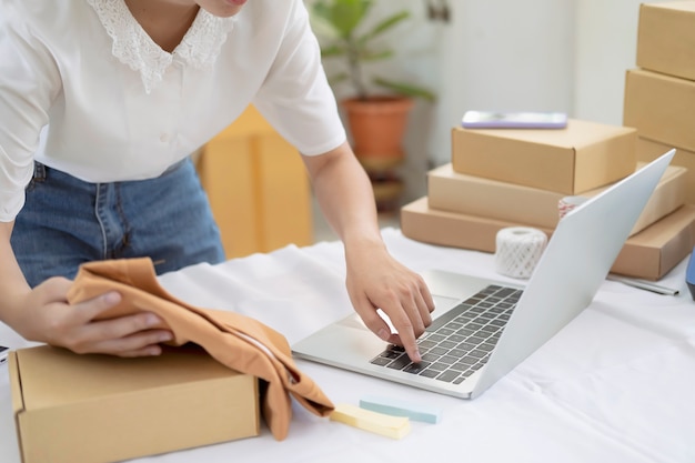 Jeune vendeur en ligne vérifiant les préducts pour préparer la boîte à colis à livrer au client